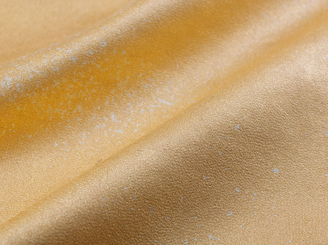 最高難度に挑む、箔を布に貼る技術。